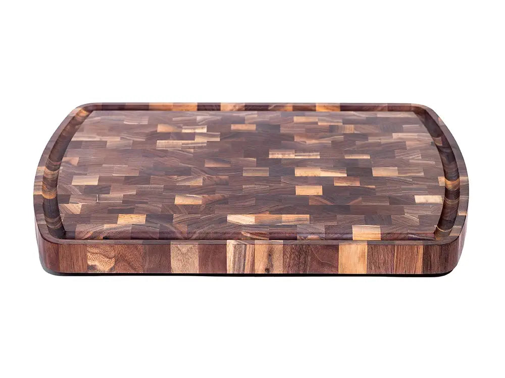 A top view of a wooden cutting board displaying a vibrant end-grain pattern with various shades of brown. The board features a juice groove running along the perimeter, emphasizing its practical and stylish design.