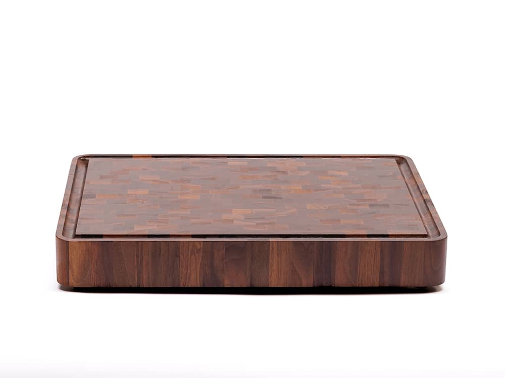 Elegantly crafted rectangular end-grain cutting board with a mosaic of light and dark brown wood pieces, exhibiting a beautiful and intricate pattern, presented against a white backdrop