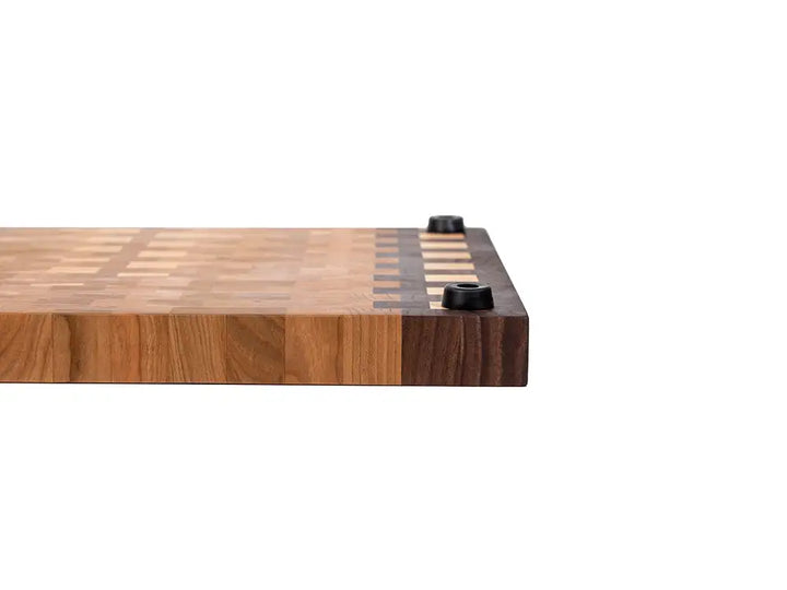 Profile of wooden cutting board displaying substantial thickness with non-slip rubber feet and grain pattern