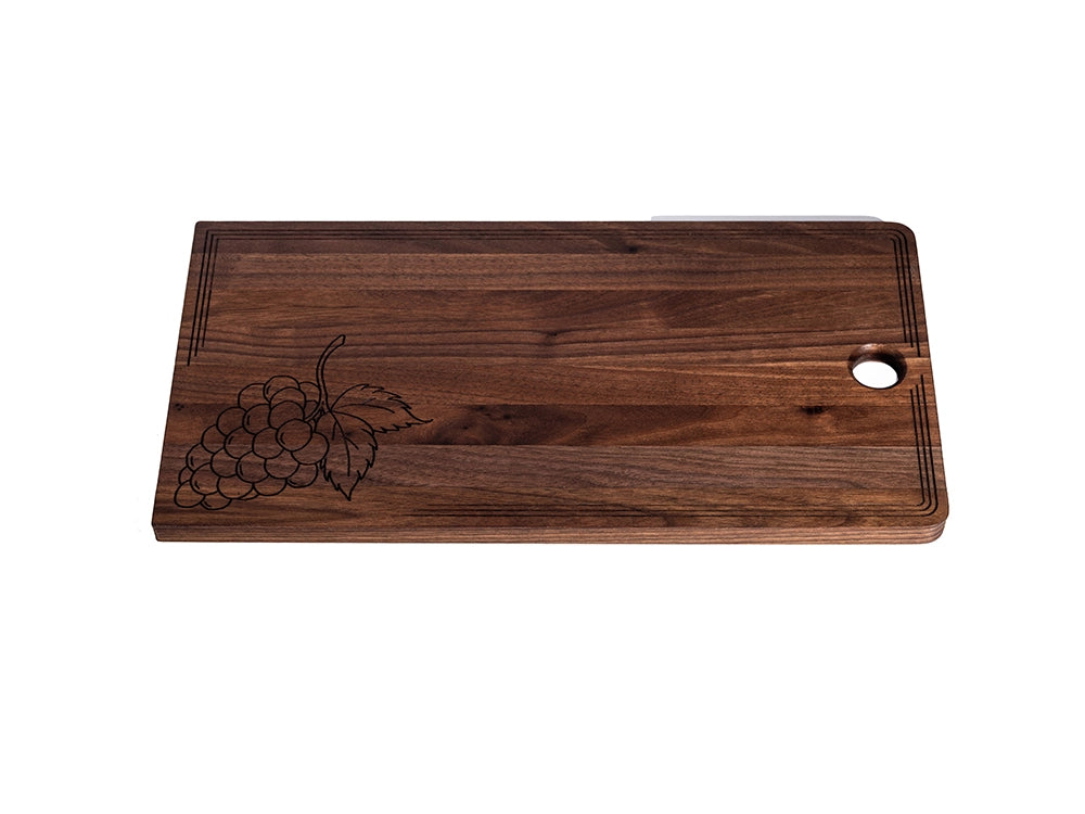 Premium black walnut charcuterie board showcasing natural grain, grape engraving, and laser-etched border.