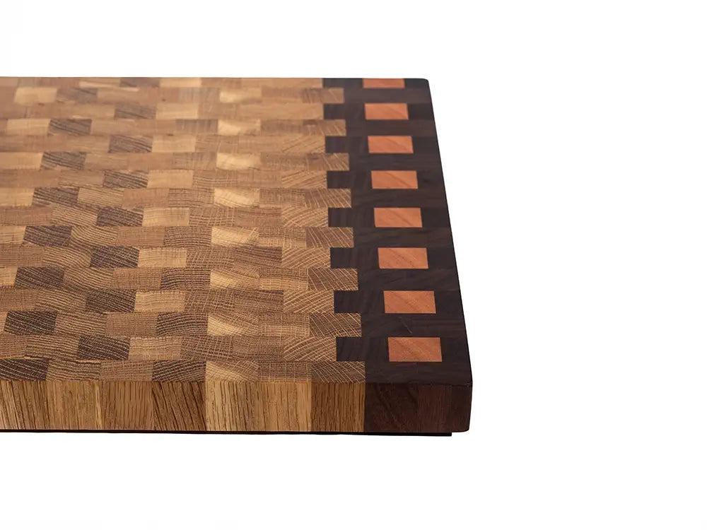 End grain cutting board edge detail displaying handcrafted construction and multi-wood border design
