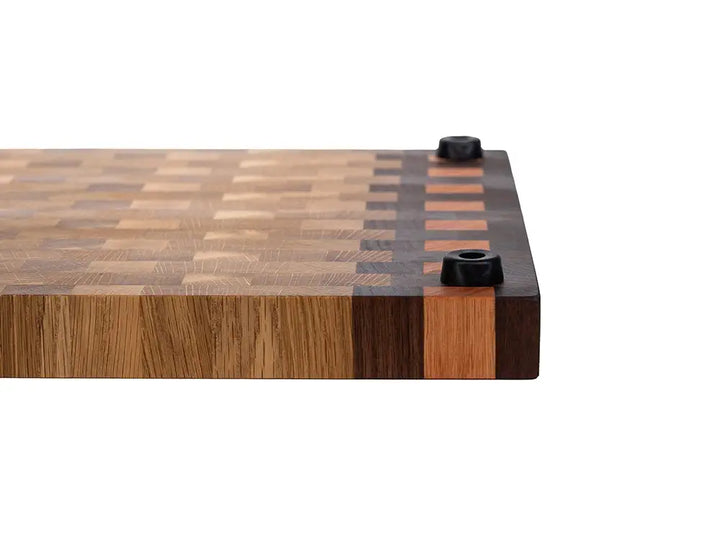Side view of wooden cutting board featuring non-slip rubber feet and thick end grain construction
