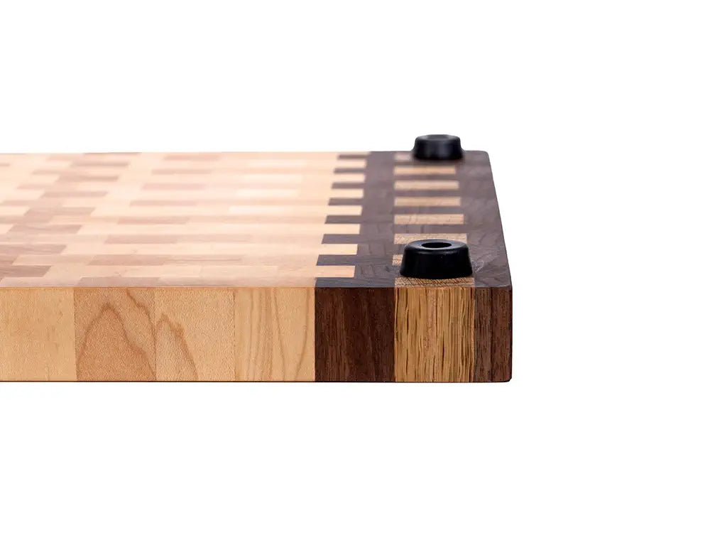 Side view of end grain cutting board with walnut accent strip, striped inlay pattern, and rubber feet 