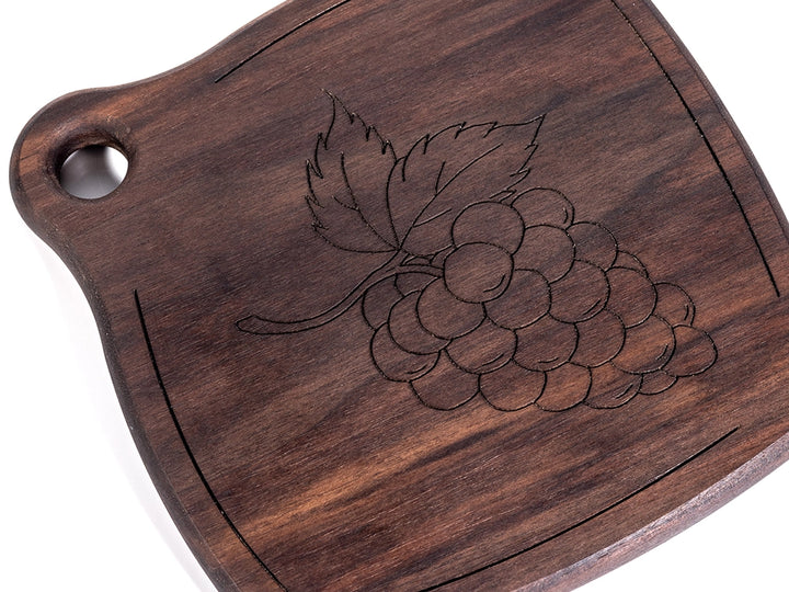 Wooden Trivet with engraved grapes design on a white background