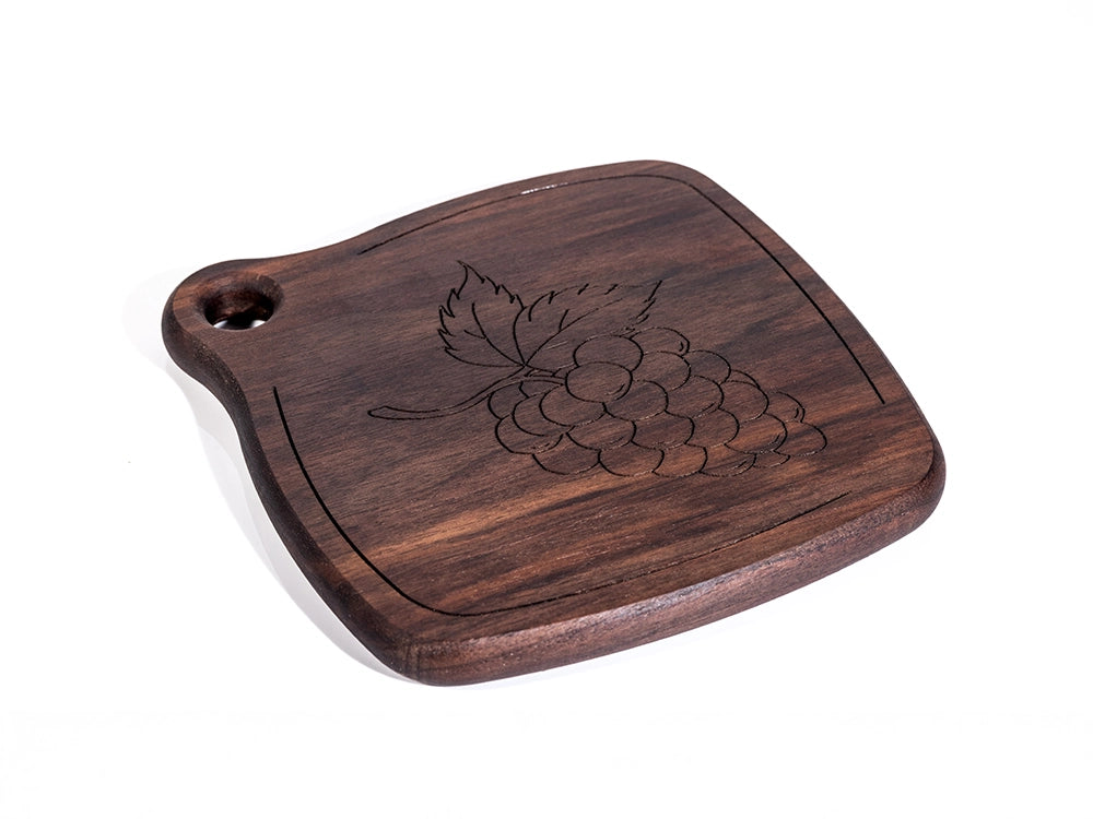 A side view of a Wooden Trivet with engraved design on a white background