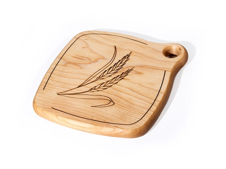 A close-up view of a Wooden Trivet with engraved Wheat design on a white background