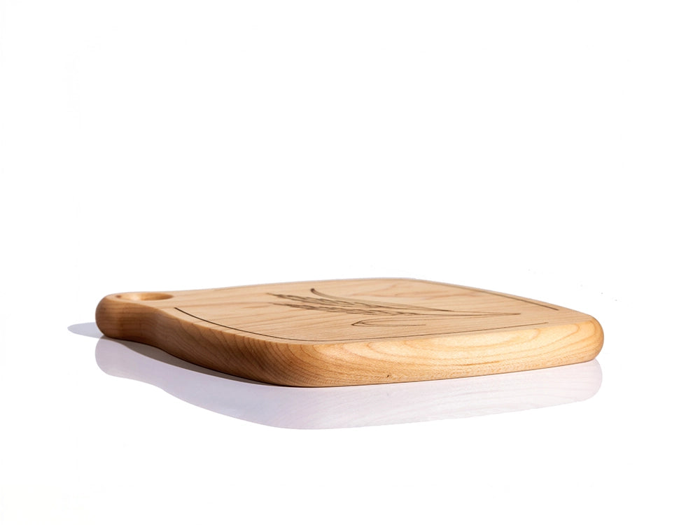 A side angle view of a Wooden Trivet with engraved Wheat design on a white background
