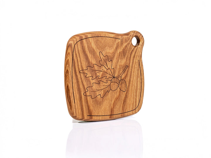 A Wooden Trivet with leaf design on a white background
