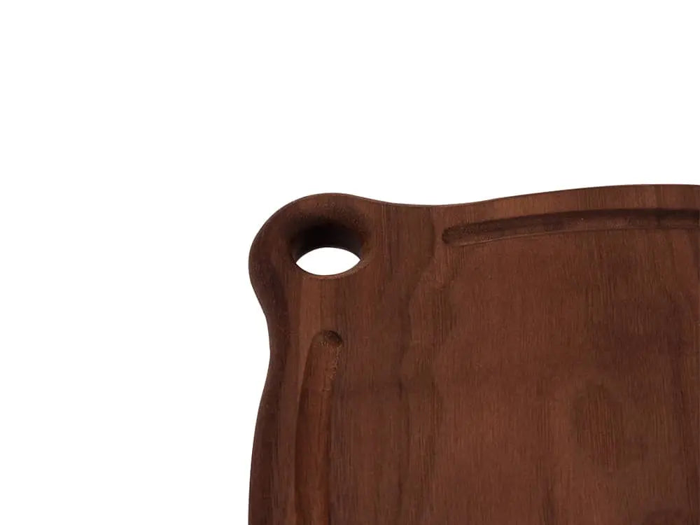 Close-up view of the Iron Wood Trivet, highlighting the grommet hole for hanging and the smooth, glossy finish on the dark walnut wood, on a white background